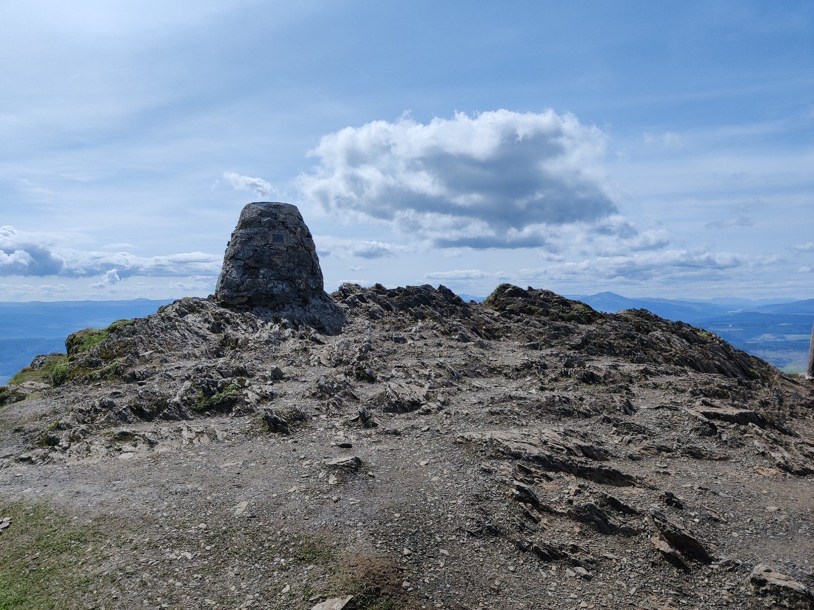 The summit marker at the top of the mountain on sharp bare rock