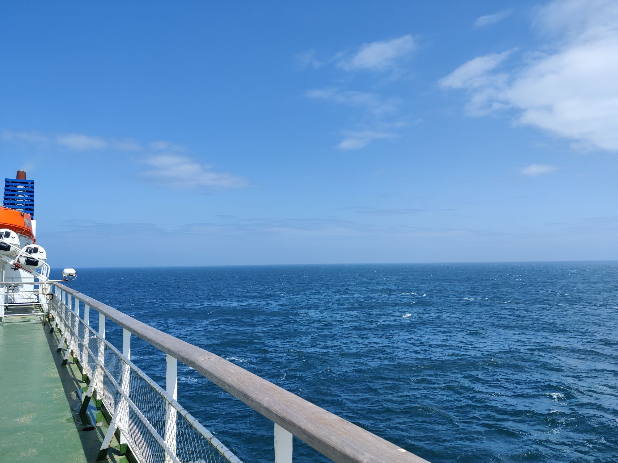 Looking out over a deep blue sea with a clear sky, off the edge of a ferry